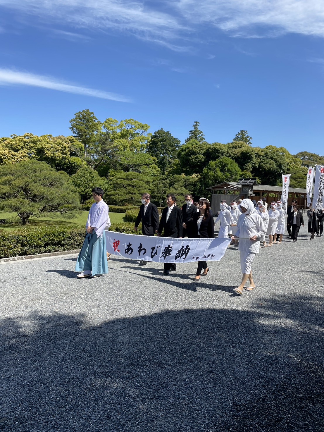祝あわび奉納ののぼりを掲げて参進するあわび王国まつり実行委員会の皆さん