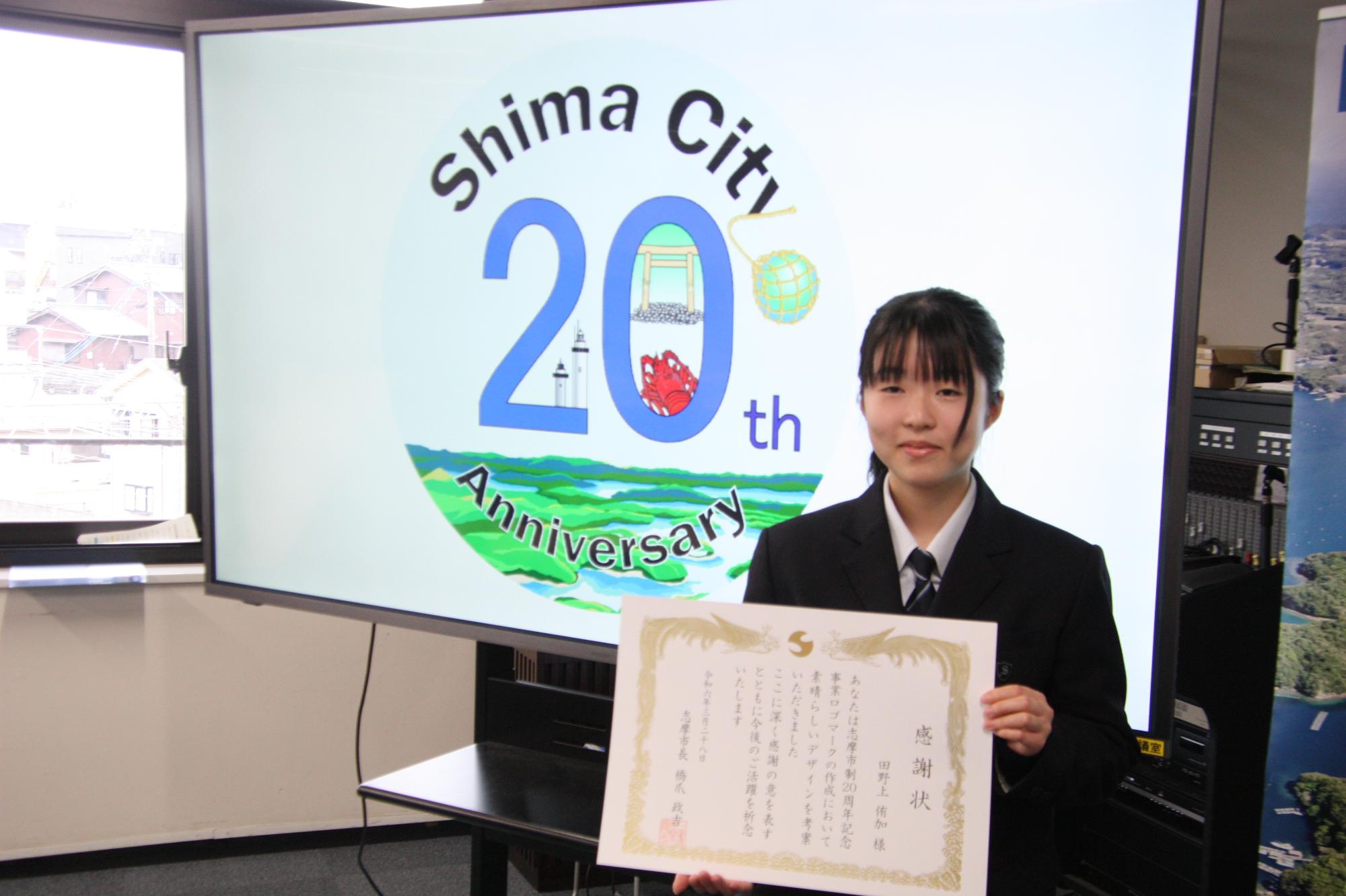市制20周年記念事業ロゴマークと原案を考案した志摩高校の田野上さん