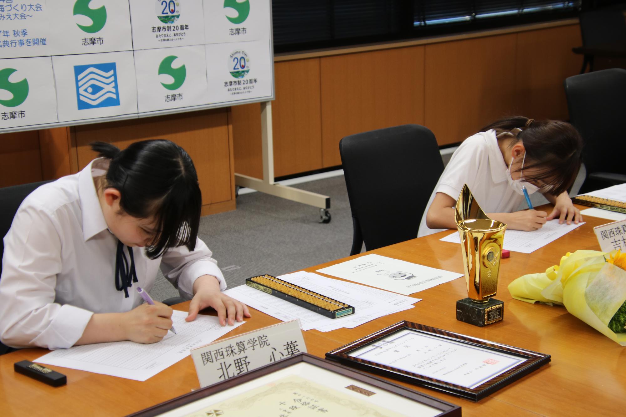 関西珠算学院報告会でデモンストレーションを披露する北野さんと吉村さん