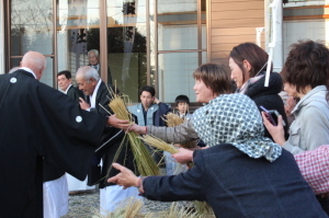 大しめ縄のわらを持ち帰る見物客